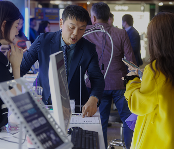 Instructor explaining materials to attendees at a booth